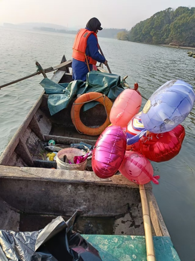 清洁工辛勤清理 跨年夜后千余气球漂浮湖面